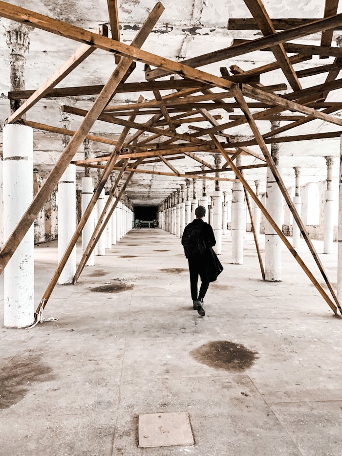 Unrecognizable man walking in building corridor under reconstruction